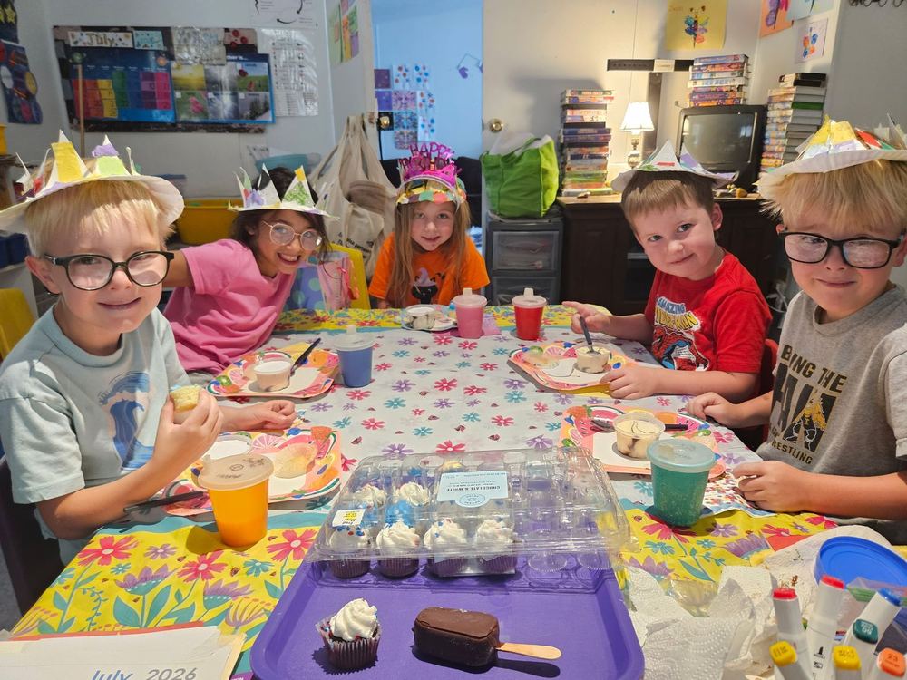 Children in paper crowns at a snack table