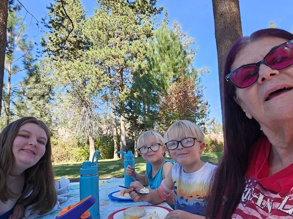Miss Lizz with children at a park picnic